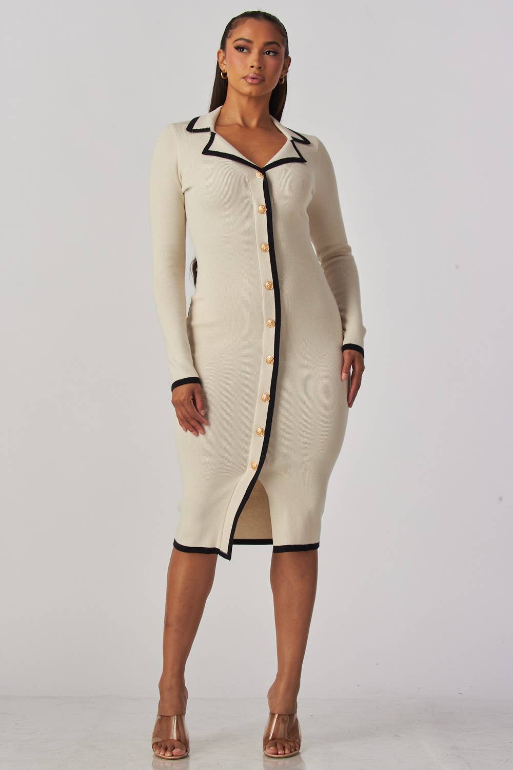 Woman wearing a cream-colored dress with black trim on a white background