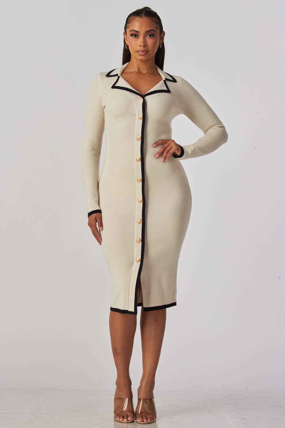 Woman wearing a beige dress with black trim on a white background