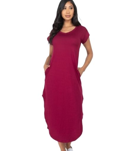 Woman wearing burgundy T-shirt maxi dress with side slit and pockets.