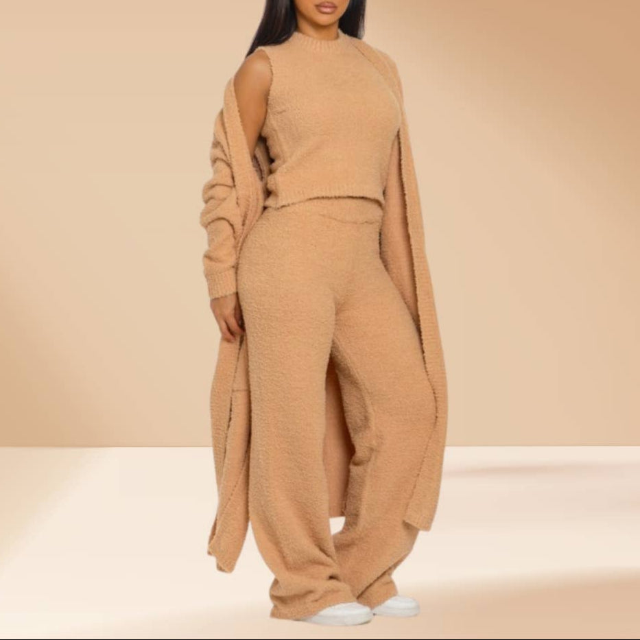 Woman wearing a beige outfit with a long duster against a beige background